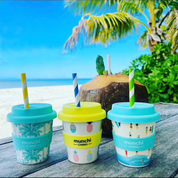 3 mini babychino cups on tropical island. Blue palm tree, yellow pineapple and blue beach style babyccino cups