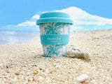 blue and green palm tree design mini babychino cup on tropical beach 